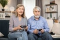 Senior people playing video games with controllers indoors Royalty Free Stock Photo