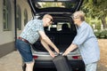 Senior people putting bags in vehicle trunk Royalty Free Stock Photo