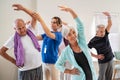 Senior people stretching with trainer at retirement community