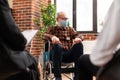 Senior person with disability attending group therapy session, wearing face mask Royalty Free Stock Photo