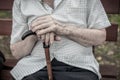 Senior person sitting on wooden bench outdoors. Old man hands ho Royalty Free Stock Photo