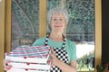 Senior pizzeria worker holding pizza boxes