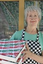 Senior pizzeria worker holding pizza boxes