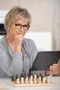 senior playing chess and looking at tablet pc Royalty Free Stock Photo