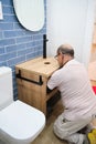 Senior plumber installer installing sink drain tube. Royalty Free Stock Photo