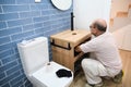 Senior plumber installer installing sink drain tube. Royalty Free Stock Photo