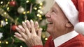 senior praying sitting by christmas tree at home Royalty Free Stock Photo