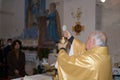 Senior priest il holding in his hand a Holy host on the altar during the celebration of the mass
