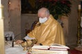 Senior priest wearing a face mack preparing celebration of the sacrament of the Eucharist