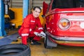 Senior professional Asian male mechanic garage worker happy working tyre wheels replacing car tire maintenance service Royalty Free Stock Photo
