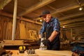 Senior Professional carpenter in uniform working of manual milling machine in the carpentry workshop Royalty Free Stock Photo