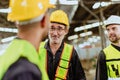 senior professional engineer male worker happy talking with young man factory employee team in industry workplace Royalty Free Stock Photo