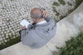 Senior professor reading and scratching head outdoors Royalty Free Stock Photo