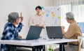 senior programmer bootcamlp,Asian young instructor guides senior learners through a programming on whiteboard, highlighting Royalty Free Stock Photo