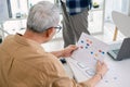 Senior programmer planning software development with flowchart and system process documentation at office Royalty Free Stock Photo