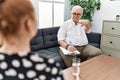 Senior psychologist man at consultation office pointing to you and the camera with fingers, smiling positive and cheerful Royalty Free Stock Photo