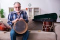 Senior male repairman repairing musical instruments at home Royalty Free Stock Photo