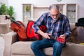 Senior male repairman repairing musical instruments at home Royalty Free Stock Photo