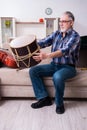 Senior male repairman repairing musical instruments at home Royalty Free Stock Photo