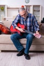 Senior male repairman repairing musical instruments at home Royalty Free Stock Photo