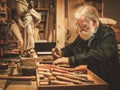 Senior restorer working with antique decor element in his workshop Royalty Free Stock Photo