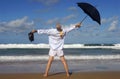 Senior retired business man, arms outstretched celebrating freedom on a tropical beach Royalty Free Stock Photo