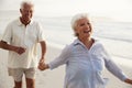 Senior Retired Couple Running Along Beach Hand In Hand Together Royalty Free Stock Photo