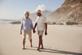 Senior Retired Couple Walking Along Beach Hand In Hand Together Royalty Free Stock Photo