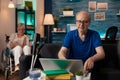 Senior retired man using laptop on table in living room Royalty Free Stock Photo