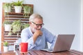 Senior retirement man is enjoy chating with someone using his laptop at home and feeling happy