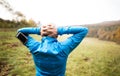 Senior runner with smartphone doing stretching. Autumn nature. Royalty Free Stock Photo