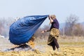 Senior rural woman burning fallen leaves