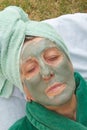 A senior's face is covered by clay facial mask.Close up Royalty Free Stock Photo