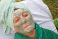 A senior's face is covered by clay facial mask.Close up Royalty Free Stock Photo