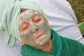 A senior's face is covered by clay facial mask.Close up Royalty Free Stock Photo