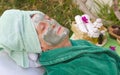 A senior's face is covered by clay facial mask.Close up Royalty Free Stock Photo