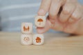 hand holding umbrella icon on wooden cube block over family, heart and house symbol for health, property ,life, family,