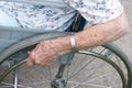 Senior's hand on wheel of wheelchair