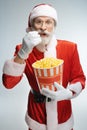 Senior Santa Claus eating popcorn from bucket
