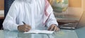 Senior Saudi Businessman Hand Writing At His Desk