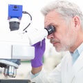 Senior scientist microscoping in lab. Royalty Free Stock Photo
