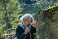 Senior sculptor with curly hair carving in stone