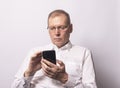 Senior serious man holding mobile phone, texting or surfing internet Royalty Free Stock Photo