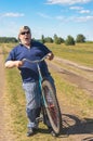 Senior shows his readiness to ride on a bicycle at country road