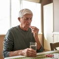 Senior sick man with glass of water taking pill Royalty Free Stock Photo