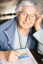 Senior solving crossword puzzle Royalty Free Stock Photo