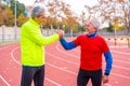 Senior sportive friends shaking hands proudly after running