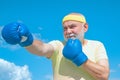 Senior sportive man in boxing stance doing exercises with boxing gloves. Active leisure. Best cardio workout.