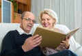 Senior spouses with picture album indoor Royalty Free Stock Photo