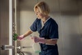 Professional chambermaid wearing uniform and gloves cleaning elevator with detergent and rag Royalty Free Stock Photo